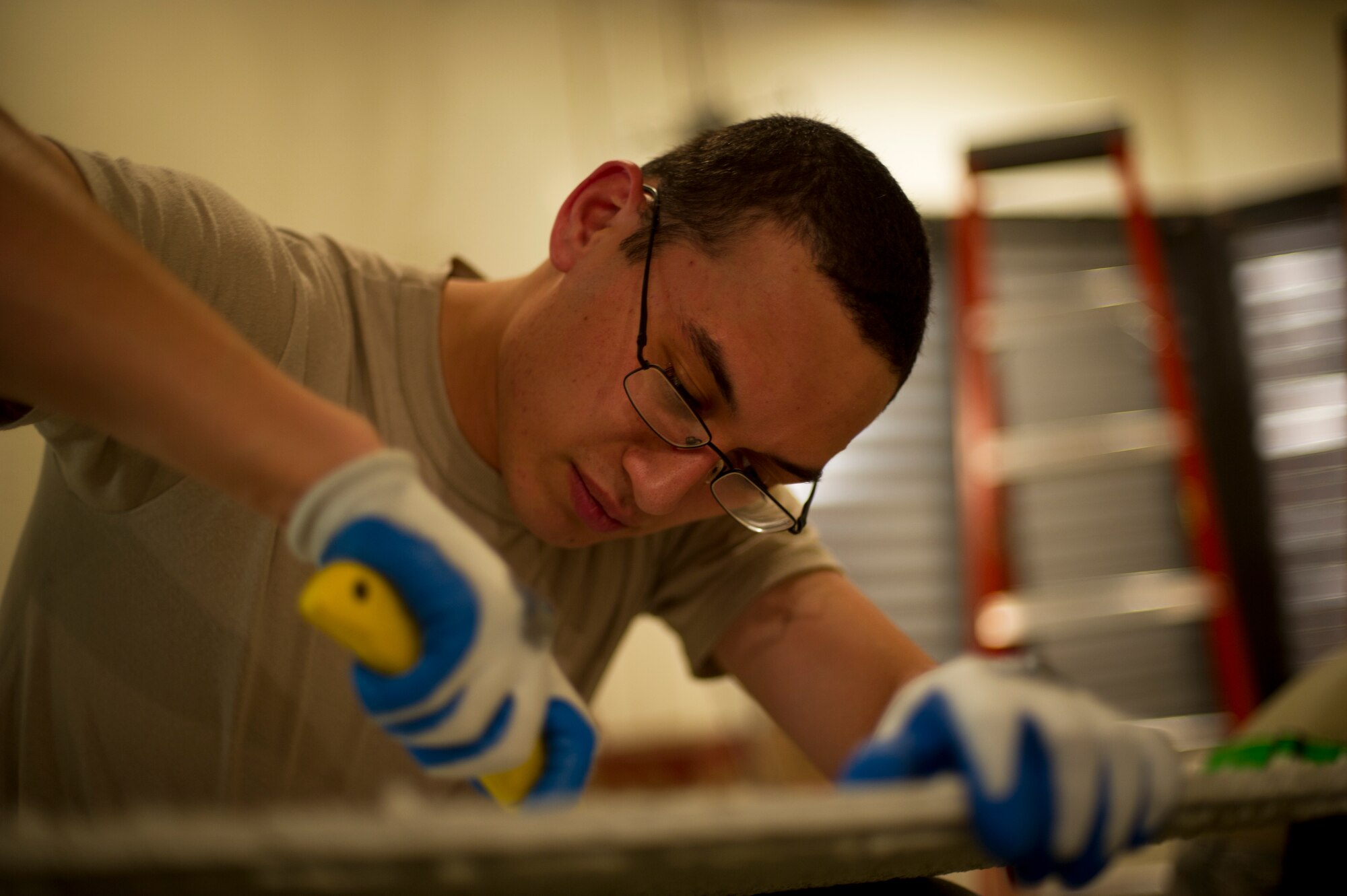 An Airman from the 5th Civil Engineering Squadron cuts a hole into a ceiling tile during reconstruction of the Law Enforcement Desk office on Minot Air Force Base, N.D., Oct. 7, 2014. The LE Desk is the primary control center for all law enforcement-based responses here, and it is also the subordinate or backup control center for all security-based responses on base.  (U.S. Air Force photo/Senior Airman Brittany Y. Bateman)