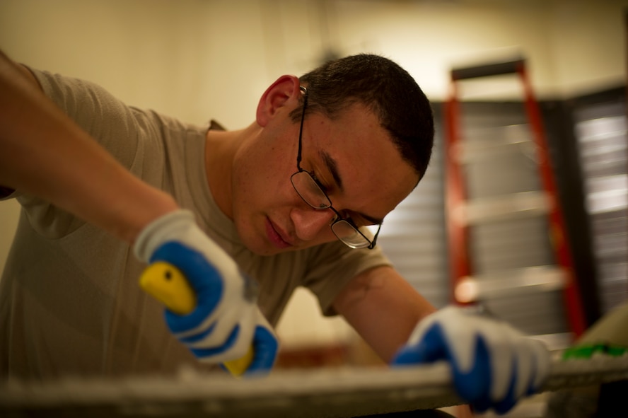 An Airman from the 5th Civil Engineering Squadron cuts a hole into a ceiling tile during reconstruction of the Law Enforcement Desk office on Minot Air Force Base, N.D., Oct. 7, 2014. The LE Desk is the primary control center for all law enforcement-based responses here, and it is also the subordinate or backup control center for all security-based responses on base.  (U.S. Air Force photo/Senior Airman Brittany Y. Bateman)