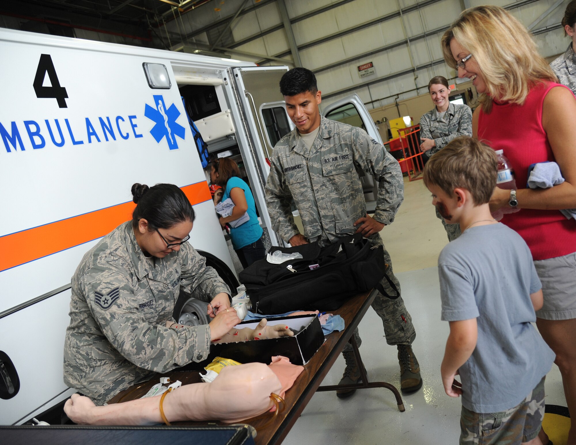 Staff Sgt. Zuleyma Perez Rodriquez, 81st Medical Operations Squadron, demonstrates a surgical procedure to the family of Lt. Col. Kevin Bray, 334th Training Squadron commander, during Operation Hero Oct. 11, 2014, at Keesler Air Force Base, Miss.  The event was designed to help children better understand what happens when their parents deploy.  (U.S. Air Force photo by Kemberly Groue)