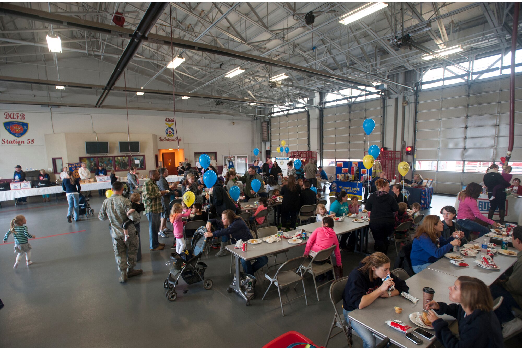 Attendees of the Military Appreciation Day open house socialize and enjoy food Oct. 10, 2014, at Dover Air Force Base, Del. The open house included free refreshments, entertainment and multiple booths to educate attendees about fire prevention. (U.S. Air Force photo/Tech. Sgt. Jeremy Larlee)