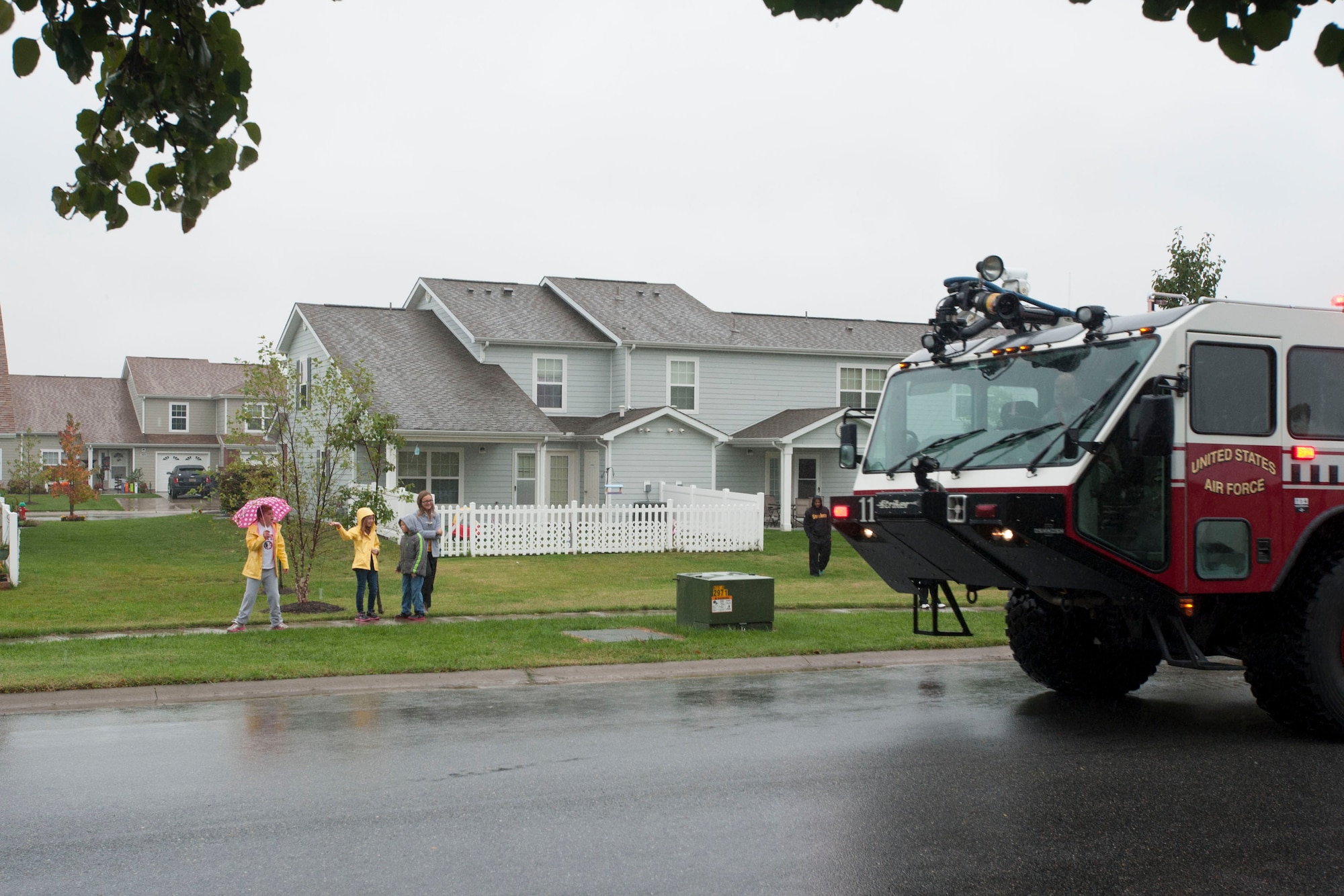 Spectators brave the rain to watch the start of a parade in honor National Fire Prevention Week Oct. 10, 2014, on Dover Air Force Base, Del. The parade and the Military Appreciation Day open house at the Fire Department closed out a busy schedule of events for the week. (U.S. Air Force photo/Tech. Sgt. Jeremy Larlee)