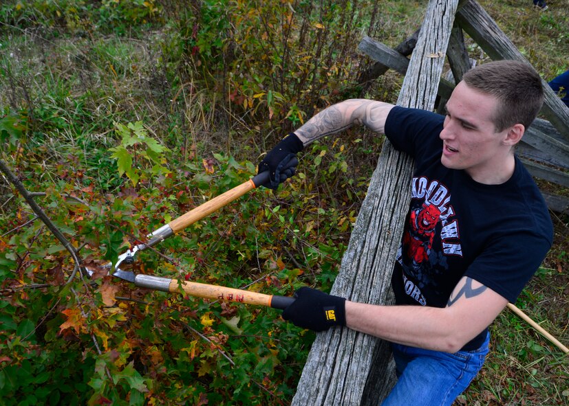 Senior Airman Tyler Kasak, 436th Maintenance Squadron aerospace pulse journeyman, cuts down overgrown brush during a volunteer event Oct. 10, 2014, at Gettysburg National Military Park, Pa. The National Park Services provided the tools and materials used to clear and rebuild a 300 yard fence line behind the Sherfy House. (U.S. Air Force photo/Airman 1st Class William Johnson)