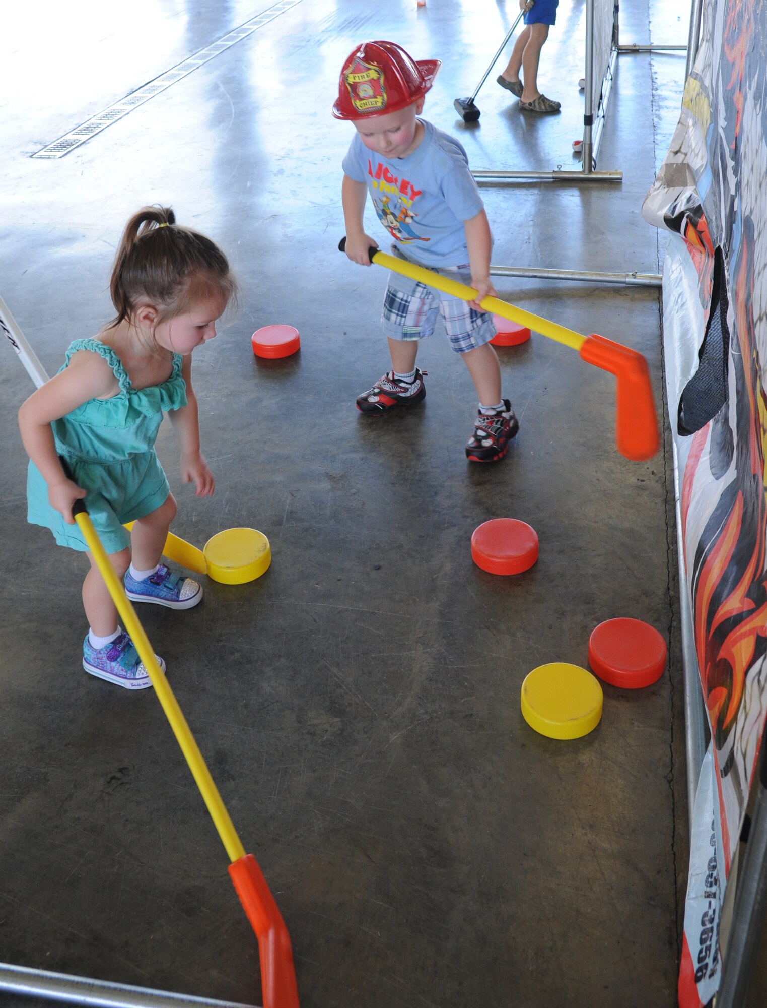 The children of Staff Sgt. Korey Papa, 334th Training Squadron, play a game of hockey during the Keesler Fire Department open house at the fire station Oct. 11, 2014, at Keesler Air Force Base, Miss.  The open house was the conclusion event to fire prevention week. Throughout fire prevention week the Keesler Fire Department conducted random fire drills, toured various facilities with Sparky the Fire Dog, passed out fire safety handouts and fire hats for children and provided stove and fire extinguisher demonstrations.  (U.S. Air Force photo by Kemberly Groue)