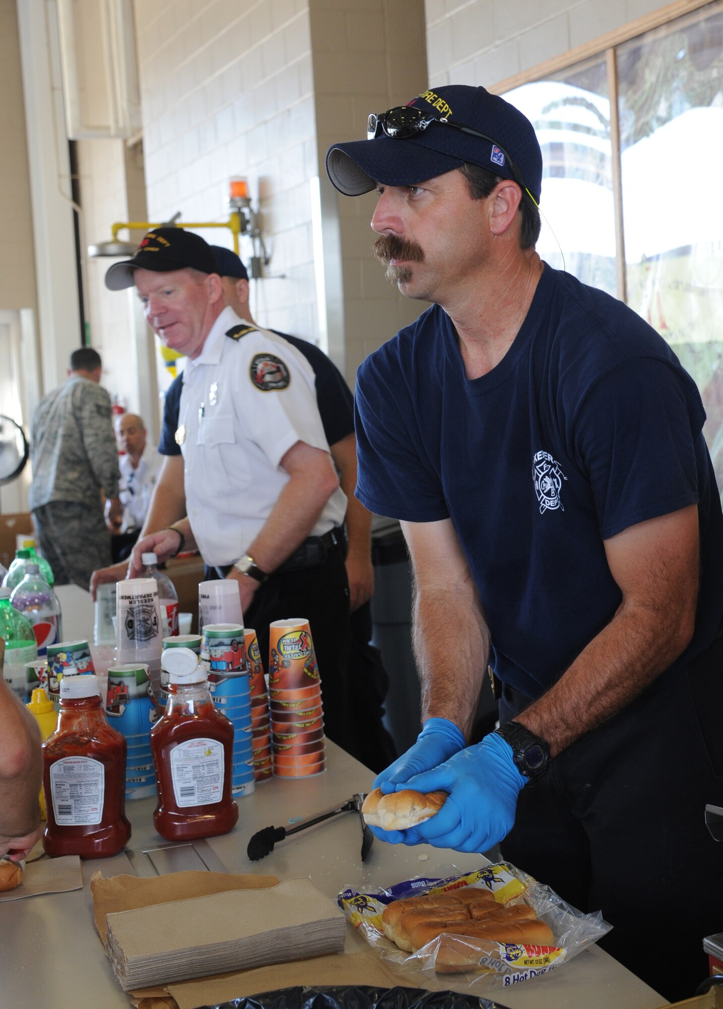 Gary Pierson and David Cleland, Keesler firefighters, provide free drinks and hot dogs during the Keesler Fire Department open house at the fire station Oct. 11, 2014, at Keesler Air Force Base, Miss.  The open house was the conclusion event to fire prevention week. Throughout fire prevention week the Keesler Fire Department conducted random fire drills, toured various facilities with Sparky the Fire Dog, passed out fire safety handouts and fire hats for children and provided stove and fire extinguisher demonstrations.  (U.S. Air Force photo by Kemberly Groue)