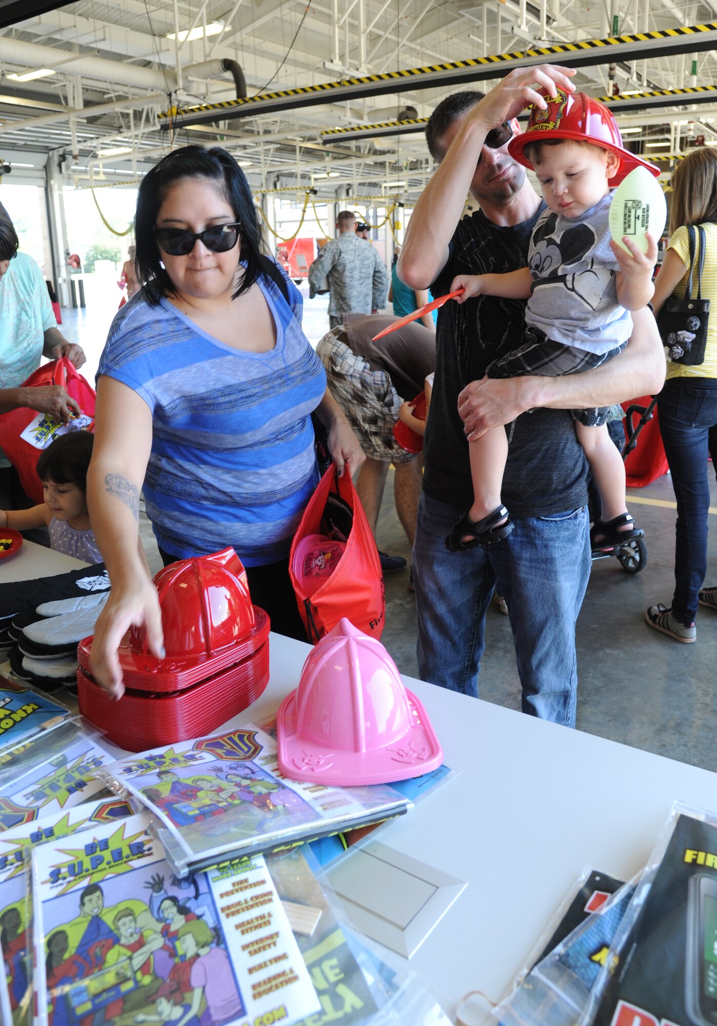 Tech. Sgt. Andrew Post, 335th Training Squadron, and his family collect gifts during the Keesler Fire Department open house at the fire station Oct. 11, 2014, at Keesler Air Force Base, Miss.  The open house was the conclusion event to fire prevention week. Throughout fire prevention week the Keesler Fire Department conducted random fire drills, toured various facilities with Sparky the Fire Dog, passed out fire safety handouts and fire hats for children and provided stove and fire extinguisher demonstrations.  (U.S. Air Force photo by Kemberly Groue)