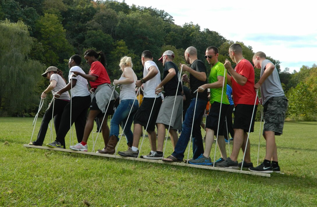 Airmen compete in a team building exercise during a Joint Base Andrews Resiliency Retreat at Wilderness Adventure at Eagle Landing in New Castle, Va., Sept. 28, 2014. This obstacle required Airmen to walk two planks without removing their feet from them. (U.S. Air Force photo/Tech. Sgt. Krystal Cruz)