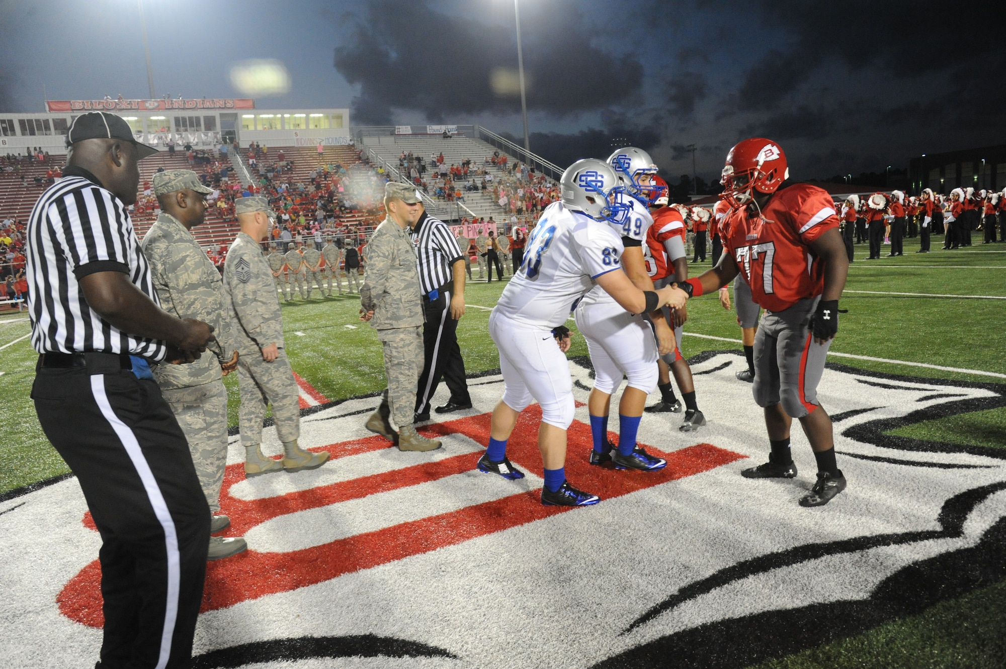Maj. Gen. Mark Brown, 2nd Air Force commander; Chief Master Sgt. David Staton, 2nd AF command chief, and Brig. Gen. Patrick Higby, 81st Training Wing commander, meet with the football team captains following the coin toss by Staton at the Biloxi High School football game against Ocean Springs High School Oct. 10, 2014, at the Biloxi football stadium.  Staton tossed the coin to determine which team would receive the ball first. Ocean Springs defeated Biloxi 35-21.  (U.S. Air Force photo by Kemberly Groue)