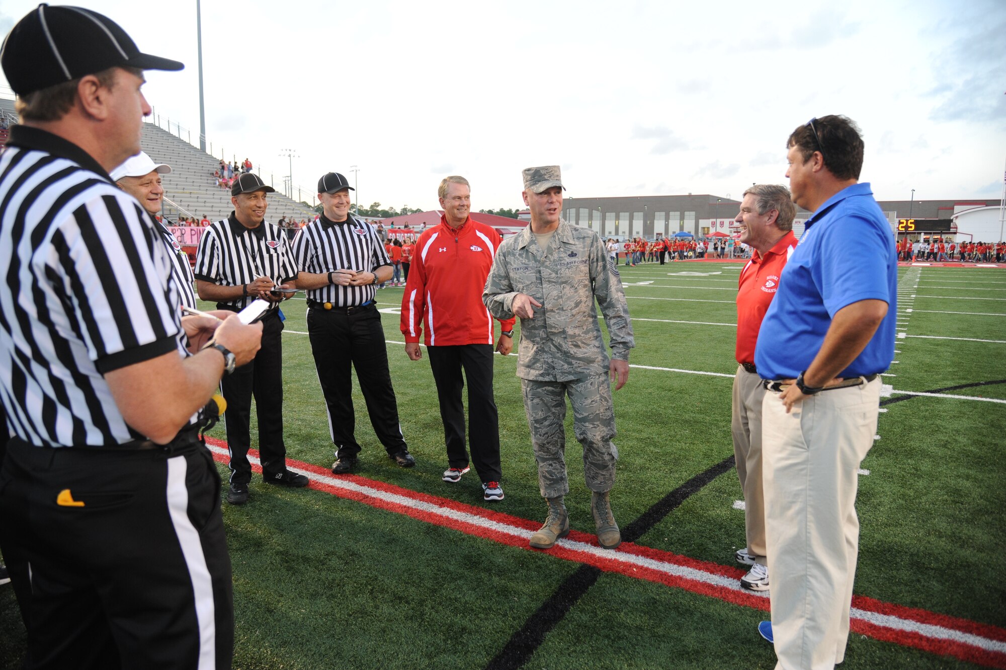 Chief Master Sgt. David Staton, 2nd Air Force command chief, meets with the head coaches and referee staff prior to the official coin toss during the Biloxi High School football game against Ocean Springs High School Oct. 10, 2014, at the Biloxi football stadium. Staton tossed the coin to determine which team would receive the ball first.  Ocean Springs defeated Biloxi 35-21.  (U.S. Air Force photo by Kemberly Groue)