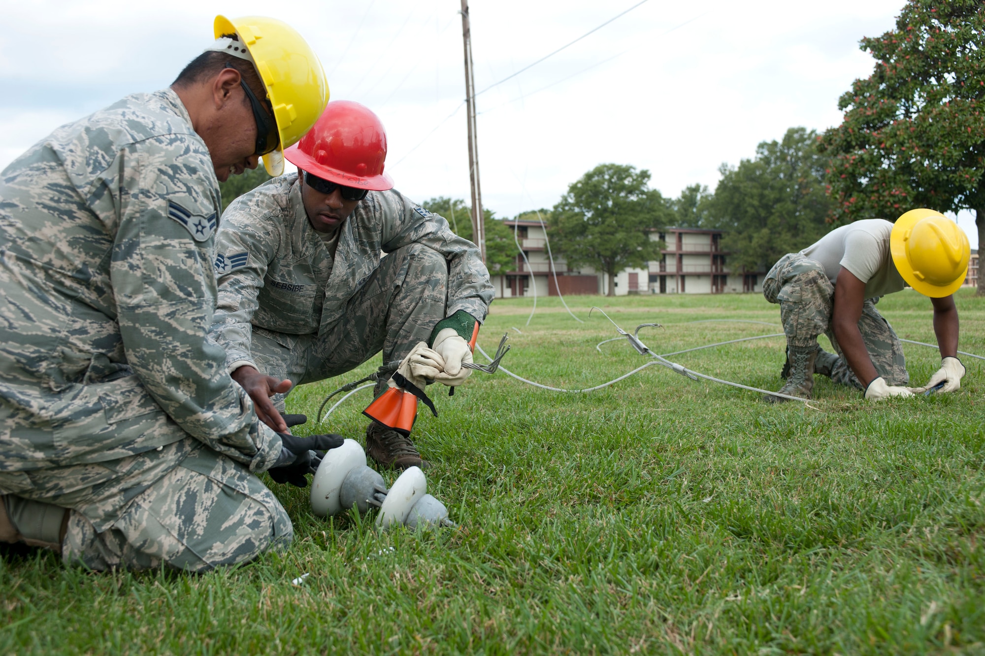 Electricians assigned to the 633rd Civil Engineer Squadron remove suspension insulators from inactive power lines at Langley Air Force Base, Va., Oct. 10, 2014. The crew removed the insulators after taking down the inactive power lines. The 633rd CES is saving all the materials taken down including power lines, poles and suspension insulators to make a training site for the squadron. (U.S. Air Force photo by Staff Sgt. Natasha Stannard/Released)