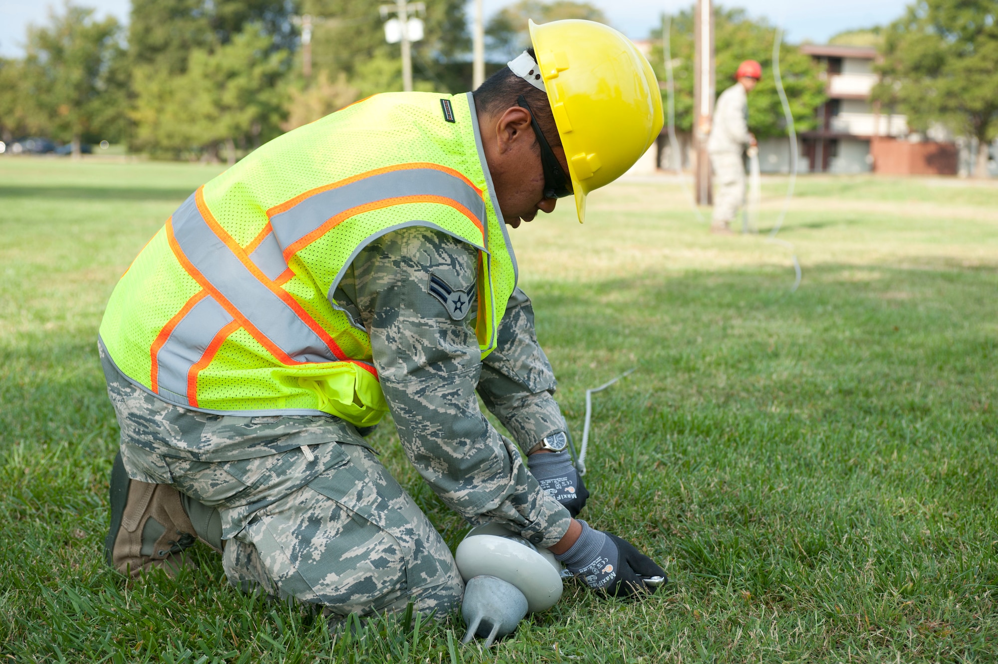 U.S. Air Force Airman 1st Class Josh Tomadad, 633rd Civil Engineer Squadron electrician, removes suspension insulators from power lines at Langley Air Force Base, Va., Oct. 10, 2014. A crew from the squadron took down the lines because they were inactive, and used the activity as on-the-job training. (U.S. Air Force photo by Staff Sgt. Natasha Stannard/Released)