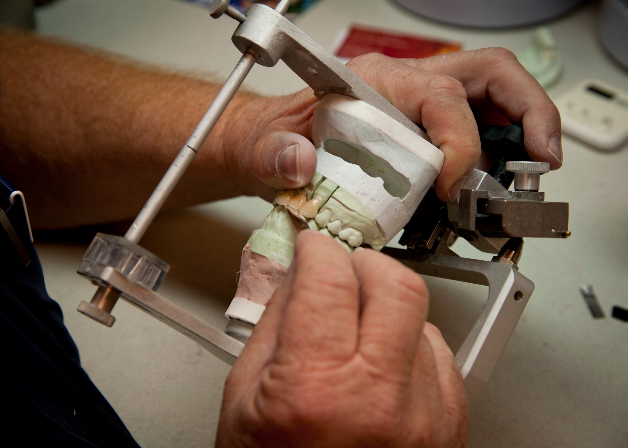 PETERSON AIR FORCE BASE, Colo. – Ron Hill, 21st Space Wing Area Dental Lab certified dental technician, examines the cast of a patient’s upper and lower dental arch at the Peterson AFB Area Dental Lab Oct. 9, 2014. Peterson’s ADL supports 121 Department of Defense installations world-wide. The latest dental appliance manufacturing methods allow products like bridges and crowns to be created in mere hours rather than days. (U.S. Air Force photo/Staff Sgt. Aaron Breeden)