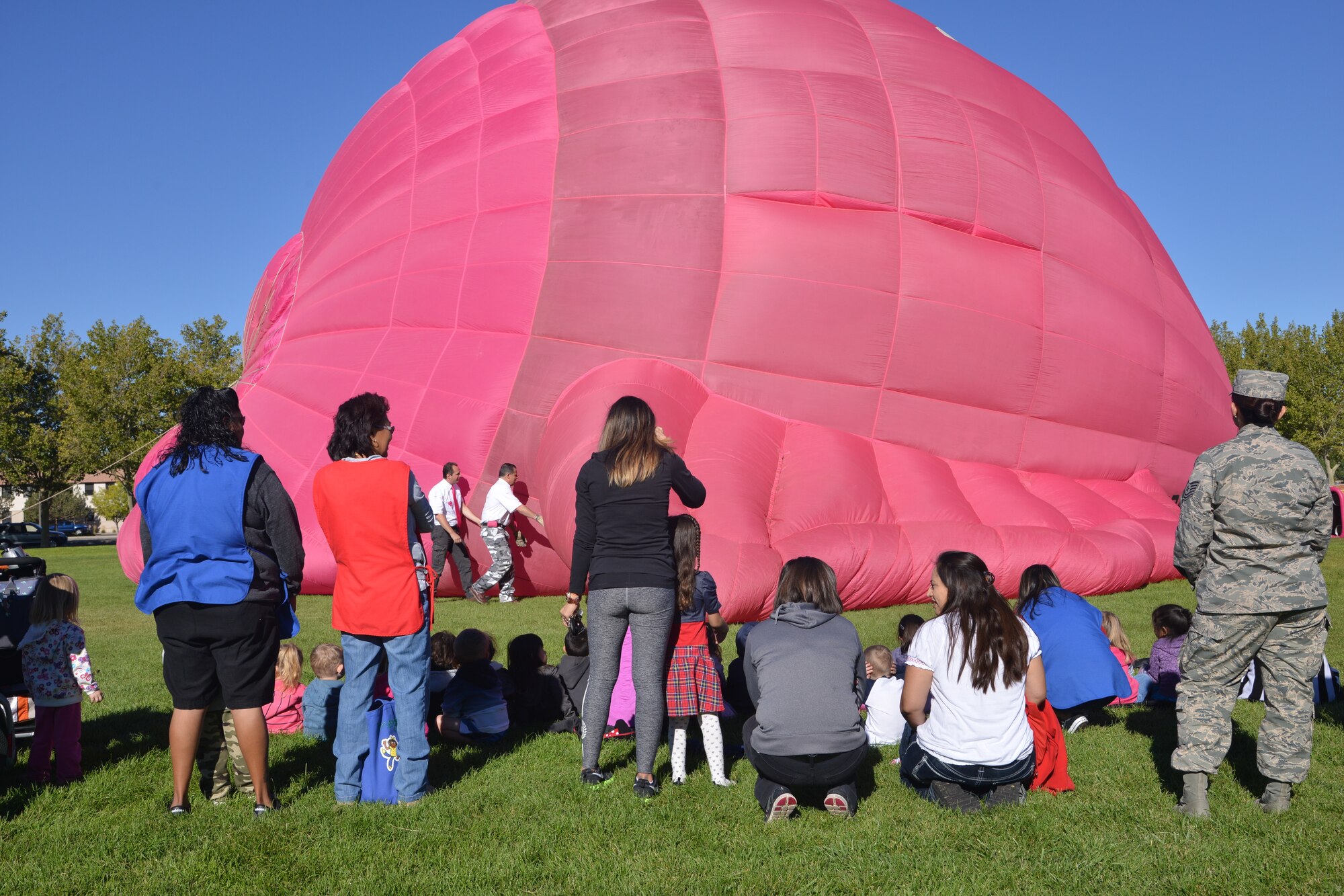 Children from Kirtland’s Child development Center on Gibson to watch as a hot air balloon is inflated at Hardin Field on Oct. 10. Peter Van Overwalle, owner of the Nelly-B hot air balloon, comes to Albuquerque each year for Balloon Fiesta and always makes a stop at the base to show off his balloon to the children. (Photo by Todd Berenger)