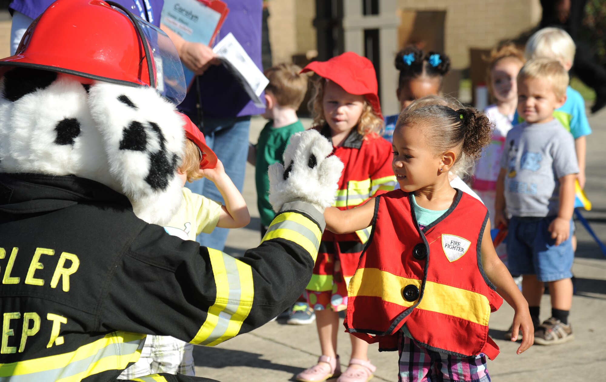 The daughter of Tech. Sgt. Jasmine Howell, 81st Force Support Squadron, gives a high-five to Sparky the Fire Dog Oct. 7, 2014, at the child development center, Keesler Air Force Base, Miss., during a visit from the Keesler Fire Department for fire prevention week. Throughout fire prevention week the Keesler Fire Department conducted random fire drills, toured various facilities with Sparky the Fire Dog, passed out fire safety handouts and fire hats for children and provided stove and fire extinguisher demonstrations.  The week–long event ended with an open house at the fire station 10 a.m. to 2 p.m. Oct. 11.  (U.S. Air Force photo by Kemberly Groue)