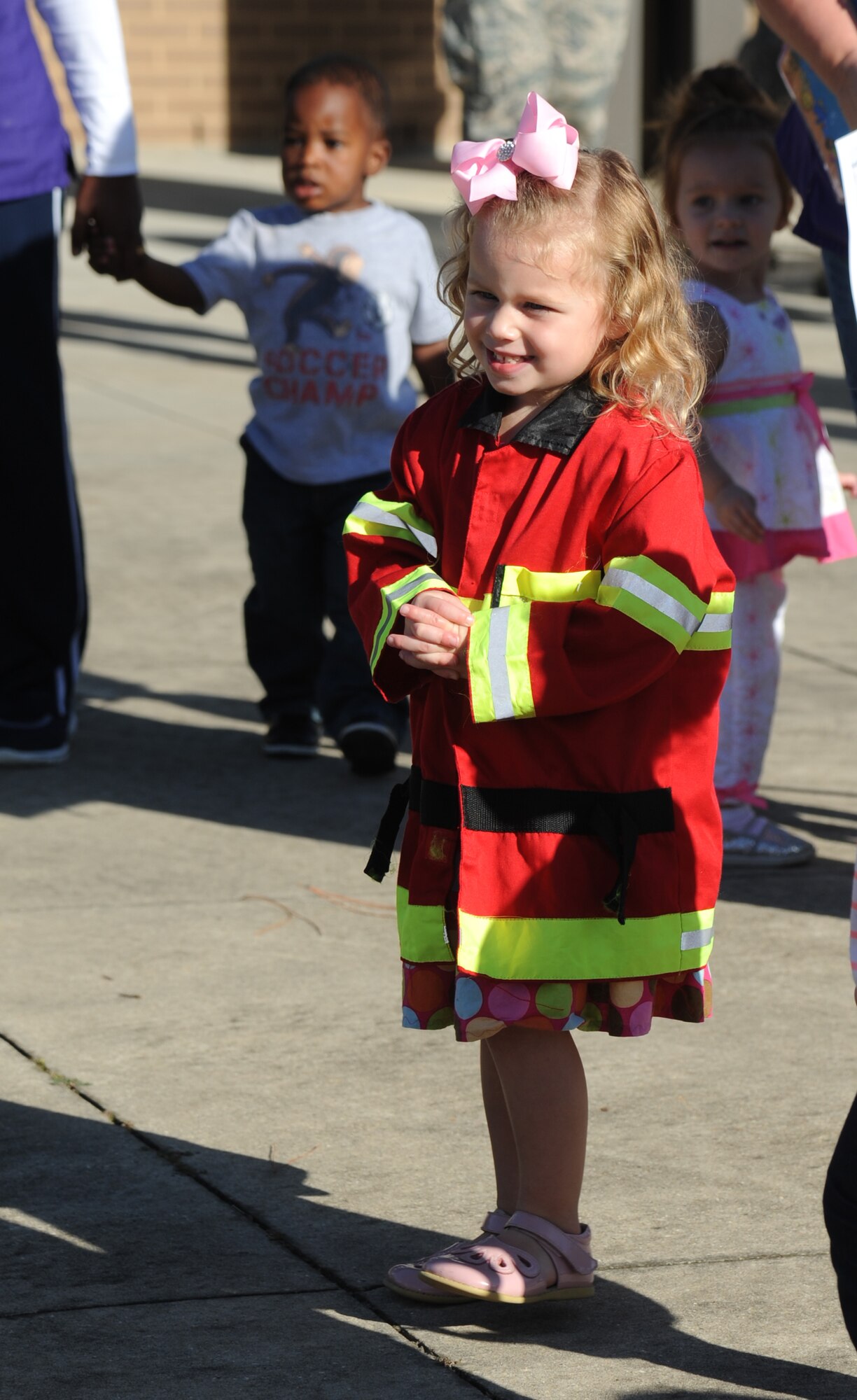 The daughter of Senior Airman Trisha Fitchett, 81st Medical Group, waits to give Sparky the Fire Dog a hug Oct. 7, 2014, at the child development center, Keesler Air Force Base, Miss., during a visit from the Keesler Fire Department for fire prevention week. Throughout fire prevention week the Keesler Fire Department conducted random fire drills, toured various facilities with Sparky the Fire Dog, passed out fire safety handouts and fire hats for children and provided stove and fire extinguisher demonstrations.  The week–long event ended with an open house at the fire station 10 a.m. to 2 p.m. Oct. 11.  (U.S. Air Force photo by Kemberly Groue)