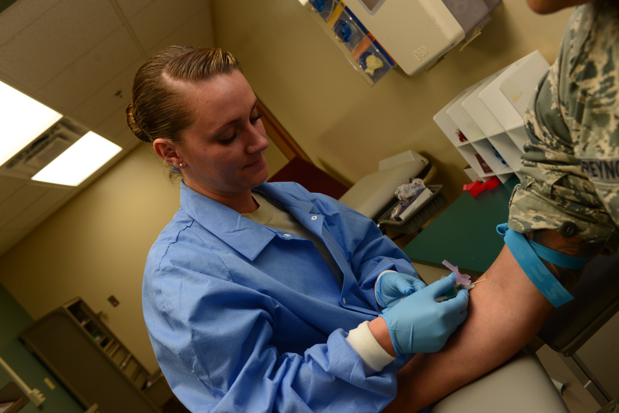 Senior Airman Brittany Harrell-Dye, 28th Medical Support Squadron medical laboratory technician, extracts blood from Tech. Sgt. Benjamin McReynolds, 28th MDSS NCO in charge of clinical laboratory at Ellsworth Air Force Base, S.D., Oct. 7, 2014. On average, the lab analyzes samples of more than 100 active-duty military members and their dependents each day. (U.S. Air Force photo by Senior Airman Zachary Hada/Released)