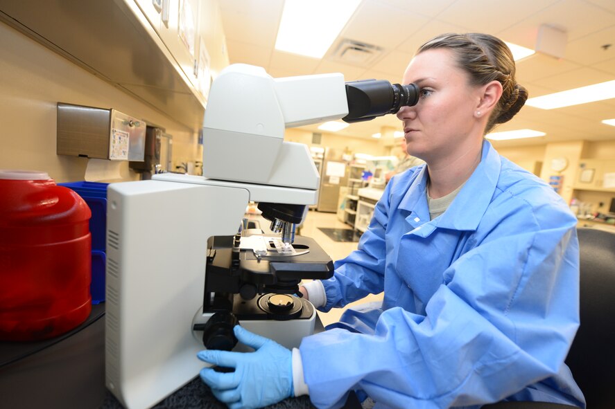 Senior Airman Brittany Harrell-Dye, 28th Medical Support Squadron medical laboratory technician, reviews a blood sample under a microscope in the clinical laboratory at Ellsworth Air Force Base, S.D., Oct. 7, 2014. Medical laboratory technicians are responsible for analyzing specimens from patients to assist physicians as they assess the health of Airmen and their families on Ellsworth. (U.S. Air Force photo by Senior Airman Zachary Hada/Released)