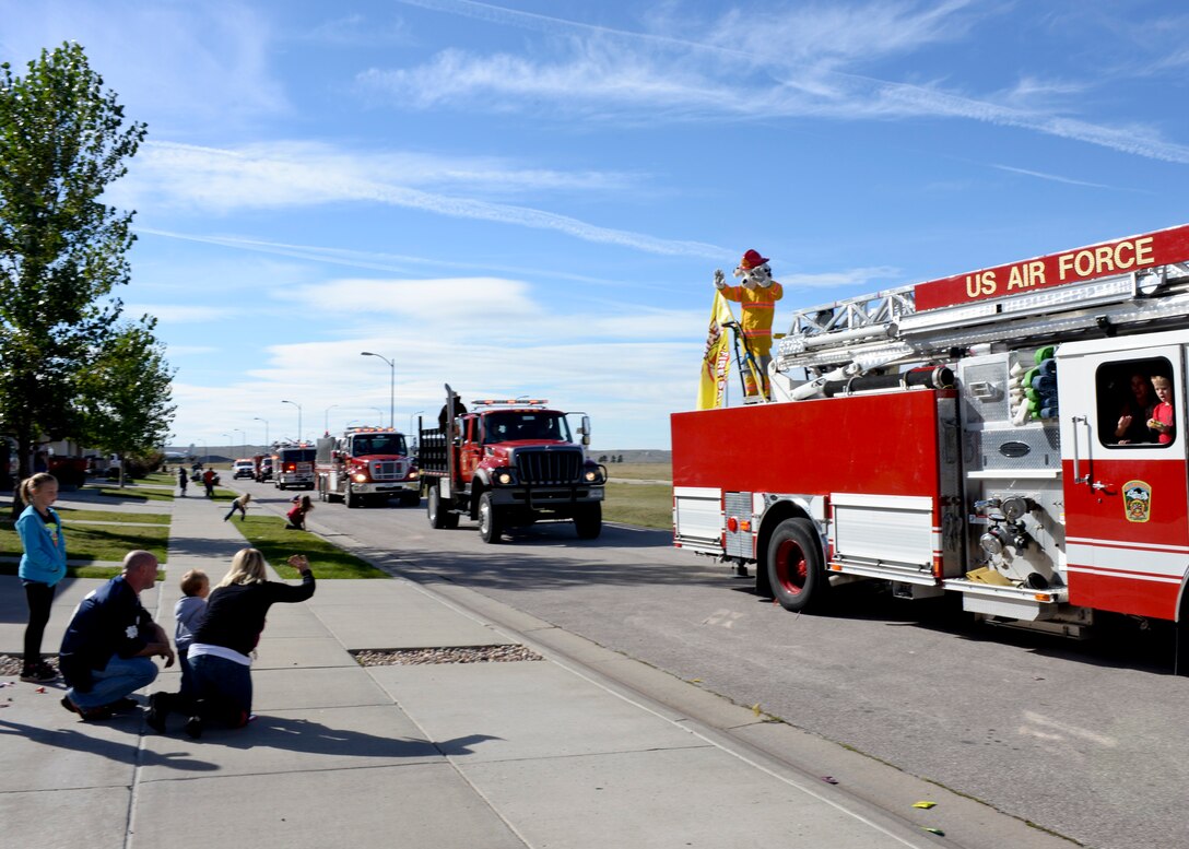 Sparky the Dog waves to base residents during a National Fire Prevention Week parade at Ellsworth Air Force Base, S.D., Oct. 4, 2014. The 28th Civil Engineer Squadron firefighters also hosted an open house later that day, offering Airmen and their families the chance to participate in activities and demonstrations about fire safety. (U.S. Air Force photo by Senior Airman Anania Tekurio/Released) 