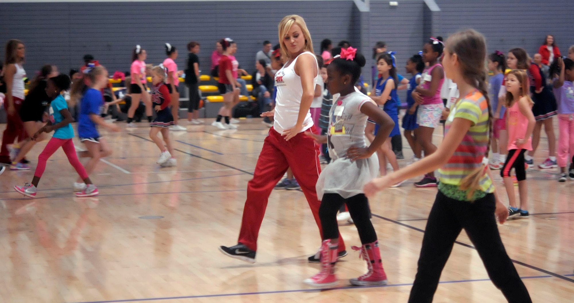 Kansas City Chiefs’ cheerleader Hayley teaches children how to strut during a cheerleading clinic at the Southside Fitness Center on Ramstein Air Base, Germany, Oct. 11, 2014. Hayley and five other Chiefs cheerleaders were brought to Ramstein by the Army and Air Force Exchange Service to show their support for the men and women of the U.S. Armed Forces and their families. (U.S. Air Force photo/Senior Airman Timothy Moore)