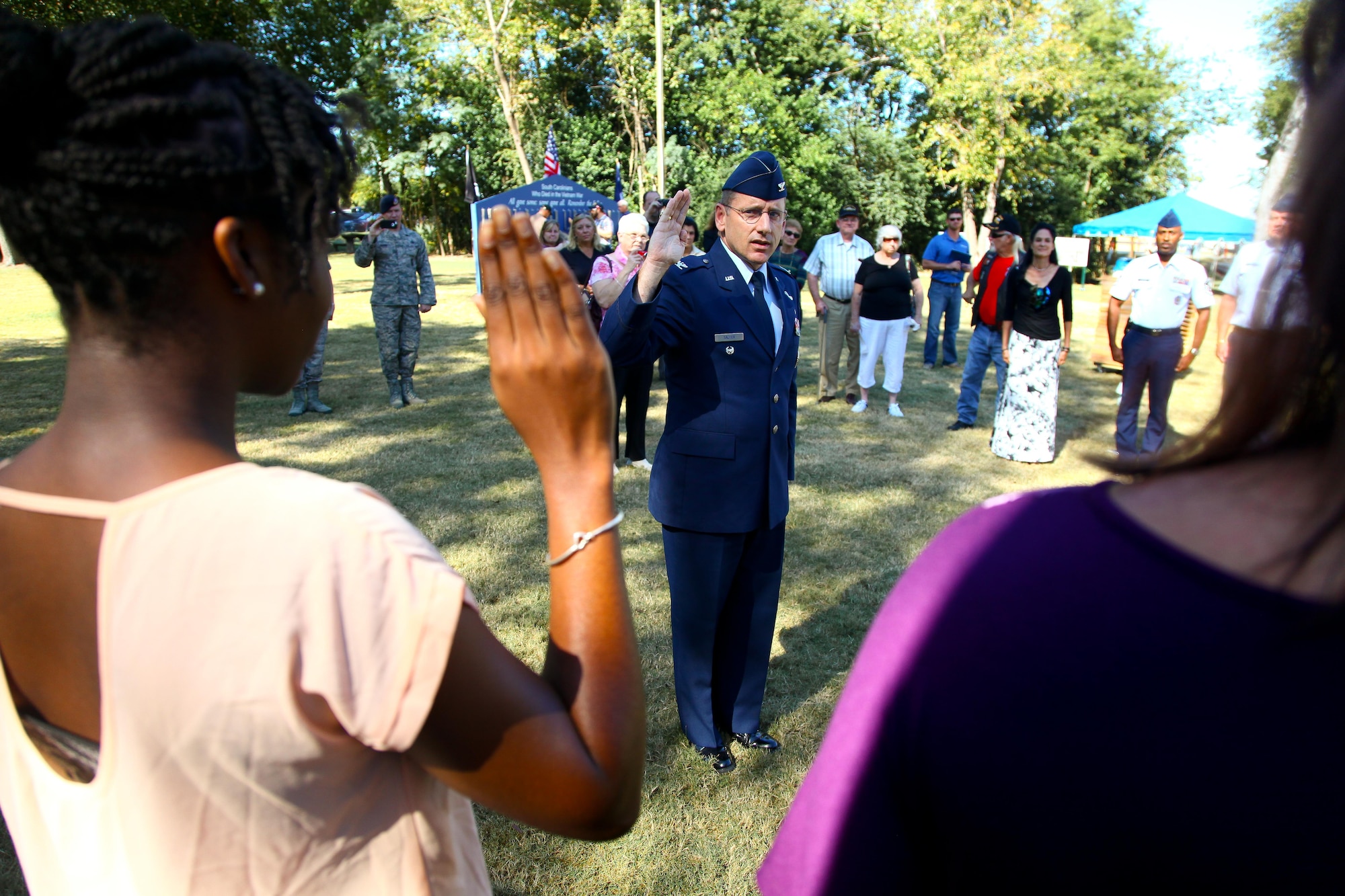Standing at attention with right hand raised, 315th Airlift Wing Commander Col. Scott Sauter looks at Niyah Sears as she repeats her oath of enlistment Oct. 10, 2014 in front of the Vietnam War Memorial at the Patriots Point Naval and Maritime Museum in Mount Pleasant, South Carolina. Sears, a Moncks Corner native, joined six others who also took their oaths of enlistments today at the Memorial. (U.S. Air Force photo by Staff Sgt. Rashard Coaxum)