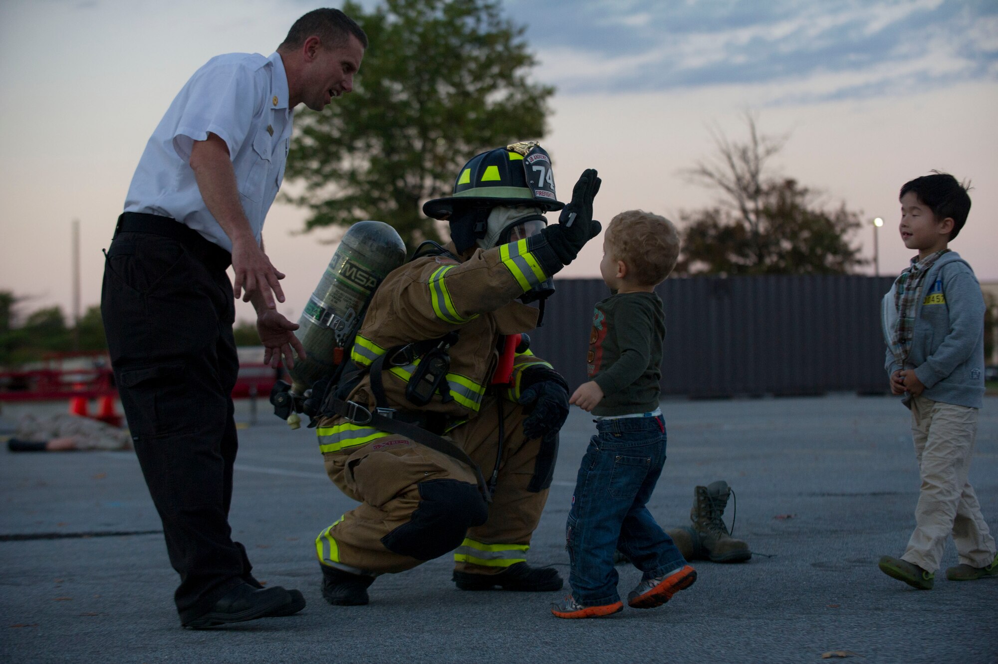 A child greets an 11th Civil Engineer Squadron firefighter during an exercise Oct. 8, 2014 at Joint Base Andrews, Md. The exercise was held in the Home Traditions parking lot and open to members of the base populace. The intent was to train and showcase the firefighter’s abilities during Fire Prevention Week. This year’s theme is “Working Smoke Alarms Save Lives, Test Yours Every Month.” (U.S. Air Force photo/Senior Airman Mariah Haddenham)