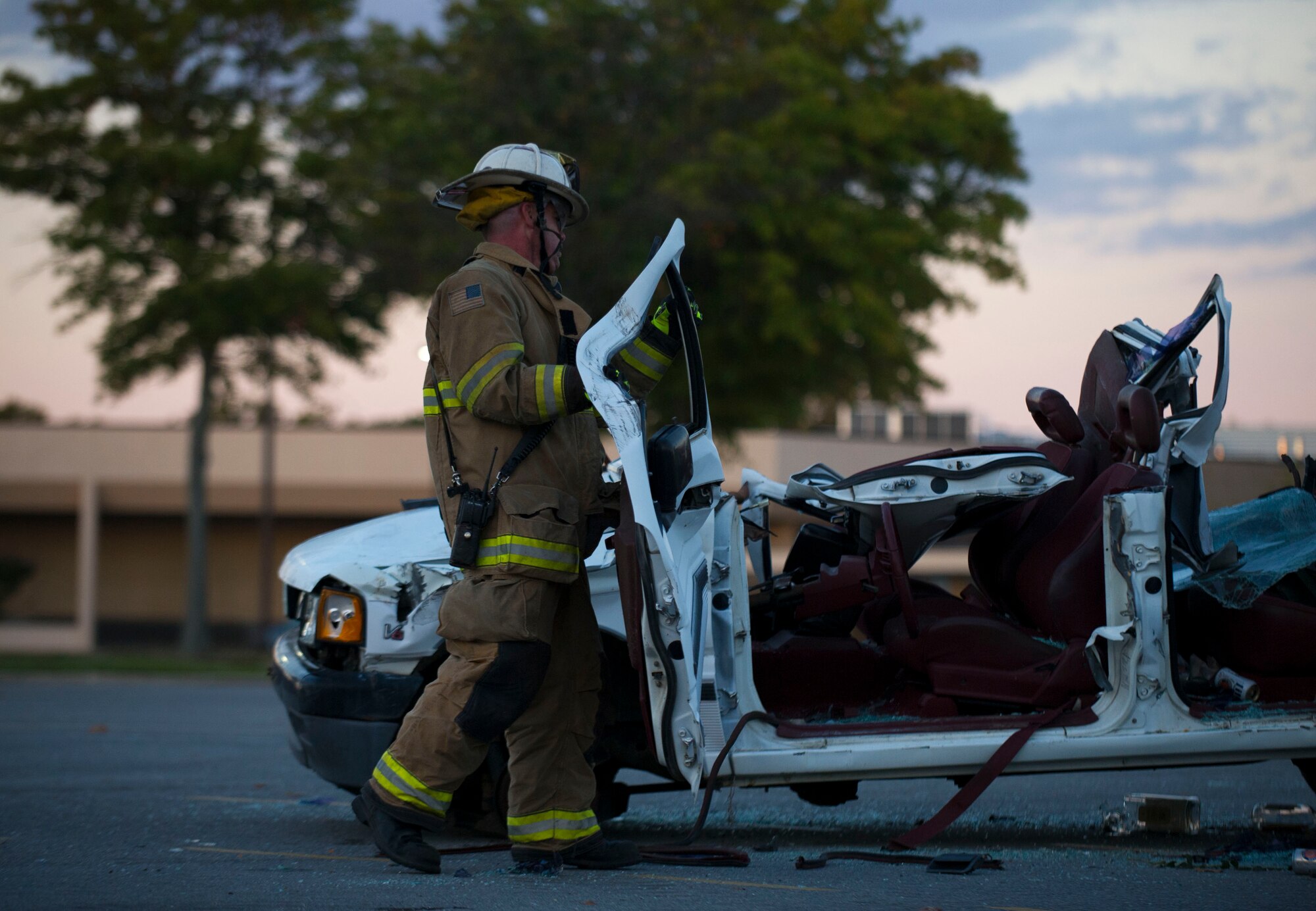 Donald Simms, 11th Civil Engineer Squadron lead firefighter, carries the car door of a disabled vehicle during a training exercise on Oct. 8, 2014 at Joint Base Andrews, Md. The car was setup to demonstrate how to extract a person out of a disable vehicle with the “Jaws of Life,” a tool used to open and rescue trapped people from a severely damaged vehicle. The firefighters participated in a variety of training simulations during Fire Prevention Week, showcasing their abilities to members of Team Andrews. (U.S. Air Force photo/ Senior Airman Mariah Haddenham)