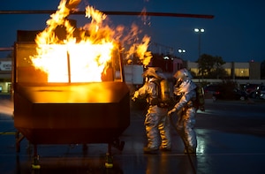 Airman 1st Class Austyn Helgeson, left, and Senior Airman Lawrence Harney, right, 11th Civil Engineer Squadron firefighters, extinguish a fire from a simulated burning aircraft during an exercise at Joint Base Andrews, Md., Oct. 8, 2014. The exercise was held to showcase the abilities of JBA firefighters during Fire Prevention Week. (U.S. Air Force photo/ Senior Airman Mariah Haddenham)