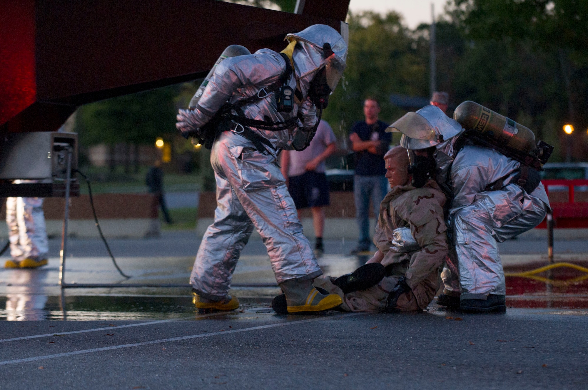 Donald Simms, left, and Airman 1st Class Donald Vickery, right, 11th Civil Engineer Squadron firefighters, simulate extracting a person from a burning aircraft during an exercise on Oct. 8, 2014 at Joint Base Andrews, Md. The exercise was held to showcase the abilities of JBA firefighters during Fire Prevention Week. (U.S. Air Force photo/ Senior Airman Mariah Haddenham)