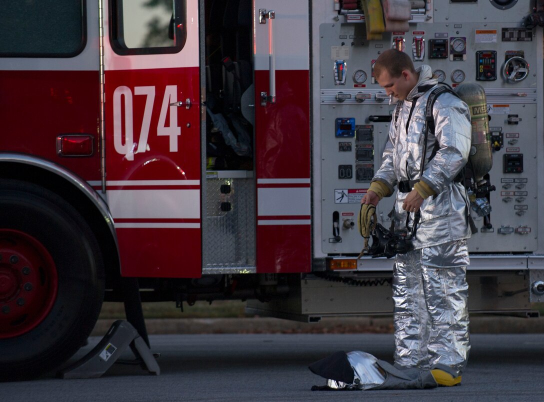 Airman 1st Class Austyn Helgeson, 11th Civil Engineer Squadron firefighter, prepares for an exercise at Joint Base Andrews, Md., Oct. 8, 2014. The exercise was held in the Home Traditions parking lot and open to members of the base populace. The intent was to train and showcase the firefighter’s abilities during Fire Prevention Week. This year’s theme is “Working Smoke Alarms Save Lives, Test Yours Every Month.” (U.S. Air Force photo/Senior Airman Mariah Haddenham)