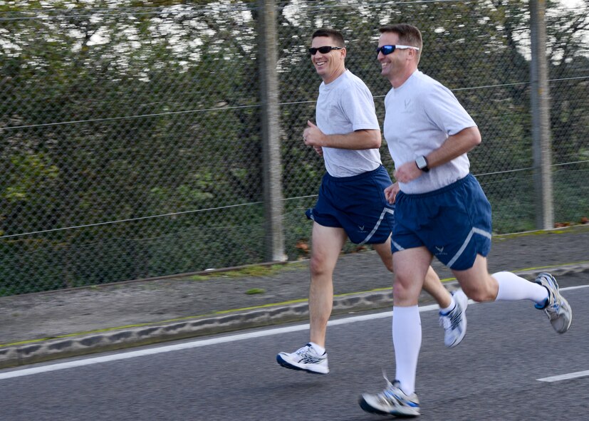 U.S. Air Force Chief Master Sgt. Tracy Jones, left, 100th Air Refueling Wing command chief, and U.S. Air Force Col. David Cox, 100th ARW vice commander, take part in the wing run Oct. 10, 2014, on Perimeter Road near the Hardstand Fitness Center on RAF Mildenhall, England. The monthly 5km run encourages morale and camaraderie throughout the base through exercise and healthy competition. (U.S. Air Force photo/Senior Airman Victoria H. Taylor/Released)