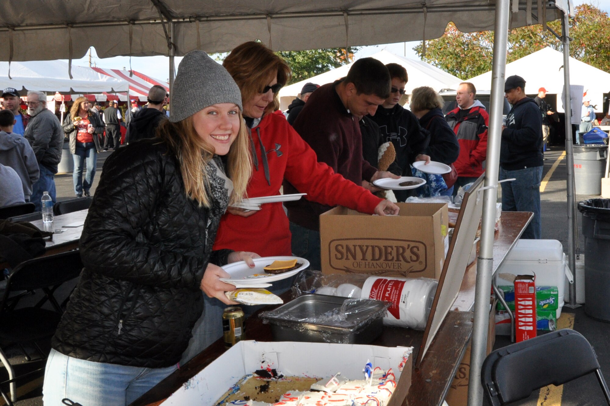 Some of the more than 80 football fans representing the Citizen Airmen of the Air Force Reserve's 910th Airlift Wing, along with their coworkers, families and friends go through the serving line at a tailgate picnic hosted by the 910th Airlift Wing here, October 11, 2014. The event, which has become a fall tradition for YARS personnel in recent years, was presented by the Youngstown Air Reserve Base-Community Council and the USO of Northern Ohio. The 910th Force Support Squadron Outdoor Recreation Office and Community Activity Center staff also supported the event. After tailgating festivities, the 910th group made their way to YSU's Stambaugh Stadium to watch the YSU Penguins 1-AA team fall to the Western Illinois Leathernecks, 30-24. U.S. Air Force photo by Master Sgt. Bob Barko Jr.