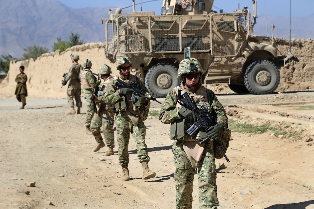 Georgian troops dismount vehicles to conduct a foot patrol through the village of Kalanasro in Bagram, Afghanistan, Oct. 11, 2014. U.S. soldiers joined them to offer training on how to correctly patrol. 