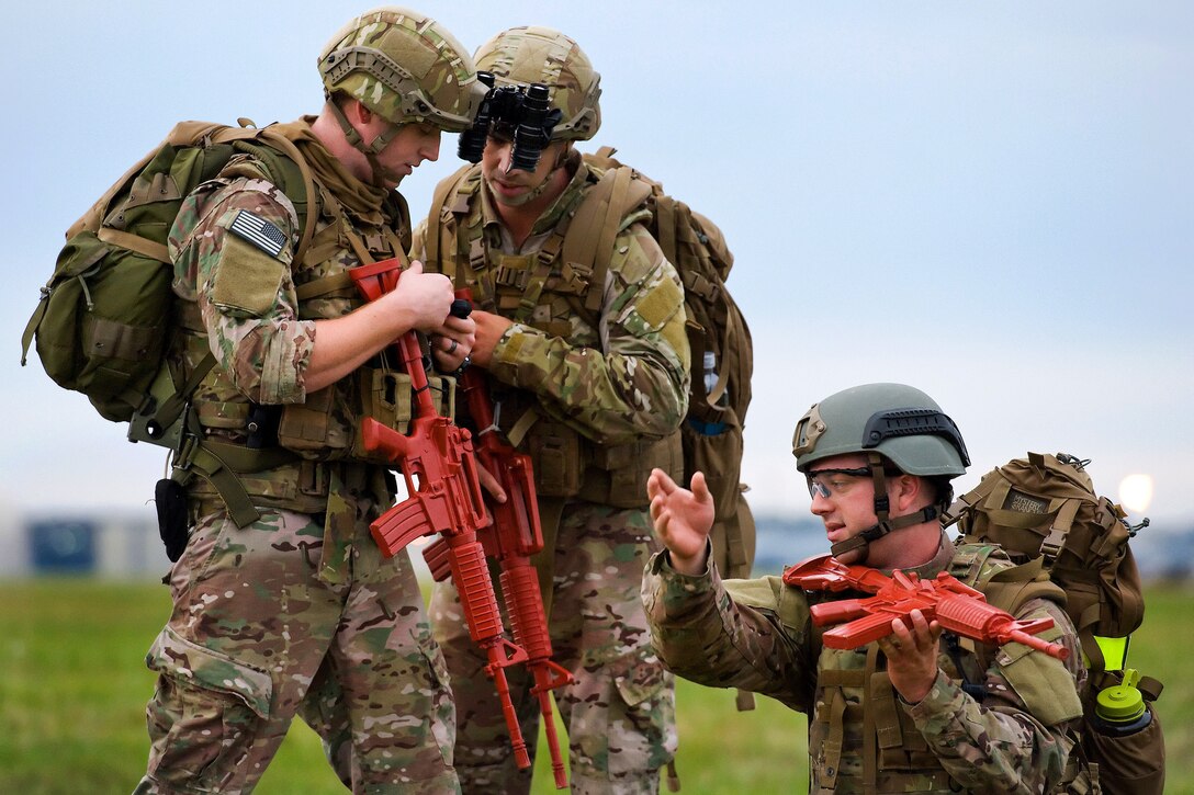 Air Force Airirman 1st Class Colby Hillman, left, and Air Force Staff Sgt. Donald Manuel, center, simulate calling in position coordinates for close air support while Air Force Staff Sgt. Carl Dill, right, points to the direction of simulated hostile fire during a training exercise on Dover Air Force Base, Del., Oct. 10, 2014. Hillman, Manuel and Dill are explosive ordnance disposal technicians assigned to the 436th Civil Engineer Squadron.
