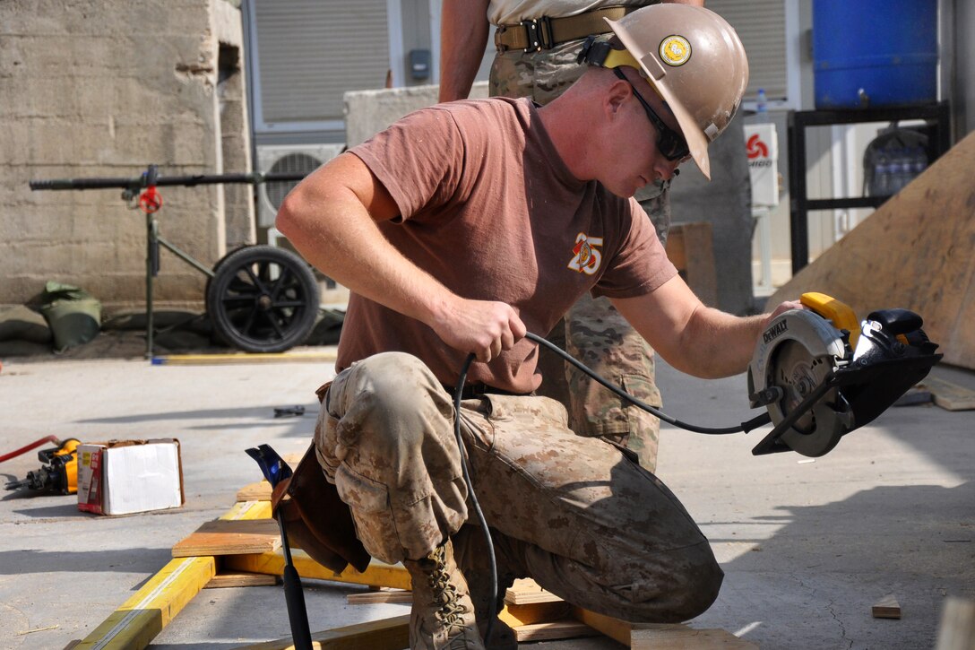 U.S. Navy Petty Officer 3rd Class Zach Mosher completes work on a roofing project for the turn-in point and mortuary affairs workspaces in Kabul, Afghanistan, Oct. 7, 2014. Mosher is a utilitiesman assigned to Naval Mobile Construction Battalion 25.