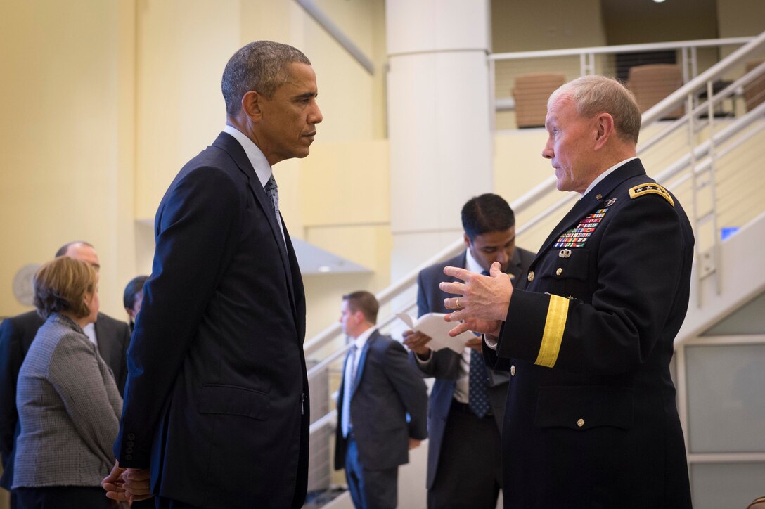U.S. President Barack Obama talks with Gen. Martin E. Dempsey, chairman of the Joint Chiefs of Staff, prior to a meeting with military leaders from 21 nations to discuss strategy in the Middle East during a conference at Joint Base Andrews, Md., Oct 14, 2014. The discussion was part of an ongoing effort to build a coalition and integrate capabilities.