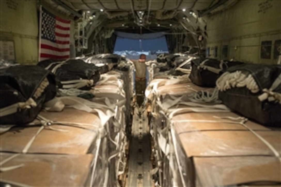 A U.S. Air Force C-130 Hercules airman checks to ensure containers filled with meals, ready to eat and fresh water sit on a C-130 Hercules aircraft in preparation for an operational resupply airdrop near the area of Bayji, Iraq, Oct. 10, 2014. The C-130 dropped bundles totaling 3,800 meals and 1,400 gallons of water. The airman is a loadmaster. 