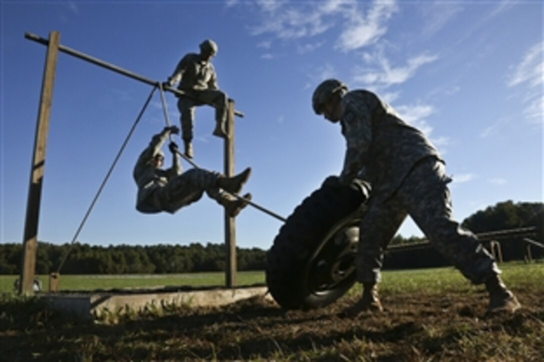 Army Sgt. 1st Class David Smith, right, navigates an obstacle course during the Best Warrior Competition on Fort Lee, Va., Oct. 9, 2014. 