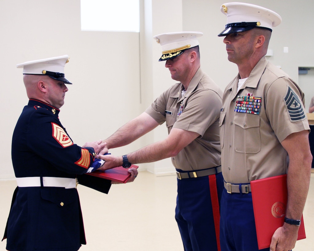 U.S. Marine Corps Gunnery Sgt. John D. Ward, left, receives his retirement flag from U.S. Marine Corps Maj. Paul Bock, Recruiting Station Frederick’s commanding officer, during his retirement ceremony at RS Frederick in Frederick, Maryland, Sept. 25, 2014. Ward, a career recruiter, retired after 20 years of service. For his dedicated and selfless service to the command and the Corps, Ward was awarded the Navy and Marine Corps Commendation Medal during the ceremony. (U.S. Marine Corps photo by Capt. Herman Davis/ Released) 