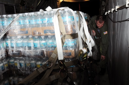 Senior Master Sgt. Thomas Obrochta, a 107th Airlift Wing C-130 load master, ensures that a pallet of water bottles destined for delivery to Haiti are secure during a relief mission executed on Feb. 8, 2010. The New York Air National Guard crew delivered 18,270 water bottles to Haiti during this mission. The 107th has provided crews along with aircraft for the transportation of supplies into and evacuees out of Haiti since four days after the earthquake hit.