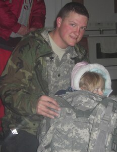 Spc. Sean Wheeler prepares a young girl for the move down the hill by securely placing her in his rucksack in Rileyville, Va., Feb. 6, 2010. Soldiers from Company A, 3rd Battalion, 116th Brigade Combat Team and volunteer firefighters from Company 1, Luray Volunteer Fire Department were dispatched to aid a family who were stranded in their home without power following a winter storm that hit Virginia on Feb. 5, 2010.