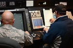 Master Sgt. Andrew Jackson, Combat Readiness Training Center RADAR approach control chief controller, and Jeff McCluskey, Federal Aviation Administration air traffic control specialist, work together to control airspace at the ATC center at Volk Field Air National Guard Base, in Camp Douglas, Wisconsin, Oct. 6, 2014. The FAA sent civilian ATC specialists to Volk Field following a fire at the Chicago ATC Center. Two of the FAA ATC specialists were also Volk Field guardsmen.