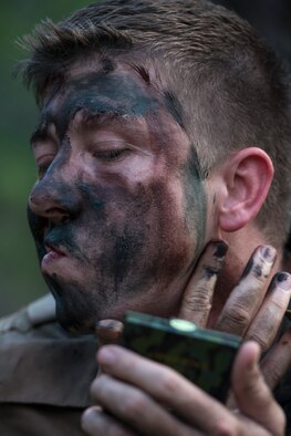 Maj. Rob Gatti applies paint to his face in preparation for a combat survival refresher course Oct. 9, 2014, at Joint Base Pearl Harbor-Hickam, Hawaii. The survival, evasion, resistance and escape combat survival refresher course is designed to familiarize aircrew members with combat skills learned through hands-on training in a realistic environment. Gatti is from the 65th Airlift Squadron. (U.S. Air Force photo/Staff Sgt. Christopher Hubenthal)