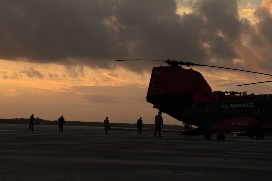 Marines with Marine Transport Squadron 1 perform an inspection for foreign objects and debris on the flight line at Marine Corps Air Station Cherry Point, N.C. as the sun rises Oct. 14, 2014. 
The Marines of VMR-1 specialize in land and sea search and rescue and transport of military personnel. VMR-1 is the only squadron in the Marine Corps whose primary mission is SAR and is the last remaining Marine Corps squadron to fly the Sea Knight.  
