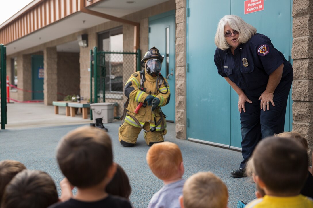 Susan Belt, a fire inspector with the Miramar Fire Department tells preschool children not to be afraid of firefighters in full gear during a fire safety class aboard Marine Corps Air Station Miramar, Calif., Oct. 14. Firefighters showed the kids what a smoke alarm is, how to move through smoke and how to stop, drop and roll. 