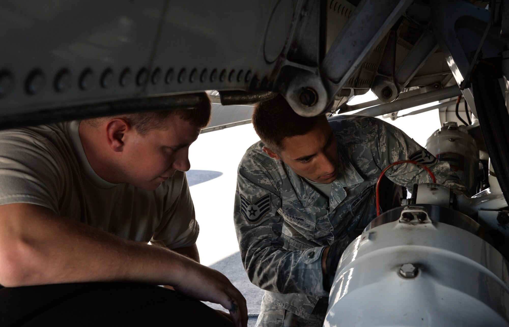 Staff Sgt. Lee Taylor (right), 15th Aircraft Maintenance Squadron C-17 Globemaster III crew chief, adjusts a C-17 jack leg while a maintenance technician overlooks Oct. 9, 2014, at Joint Base Pearl Harbor-Hickam, Hawaii. Taylor oversees the maintenance and inspection work on C-17 aircraft. (U.S Air Force photo by Staff Sgt. Alexander Martinez)