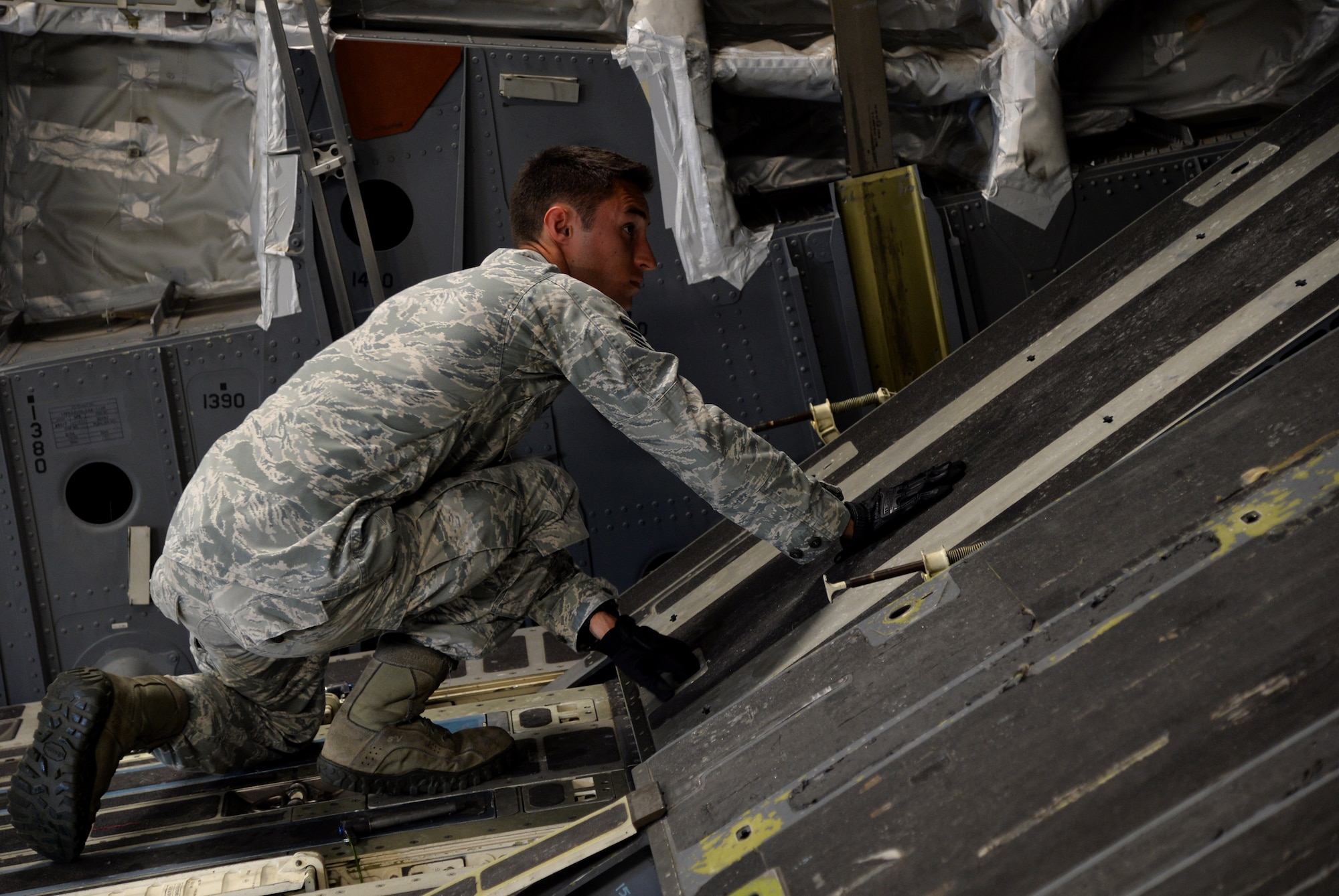 Staff Sgt. Lee Taylor, 15th Aircraft Maintenance Squadron C-17 Globemaster III crew chief, adjusts a C-17 ramp while inspecting its function Oct. 9, 2014, at Joint Base Pearl Harbor-Hickam, Hawaii. Taylor oversees the maintenance and inspection work on C-17 aircraft. (U.S Air Force photo by Staff Sgt. Alexander Martinez)