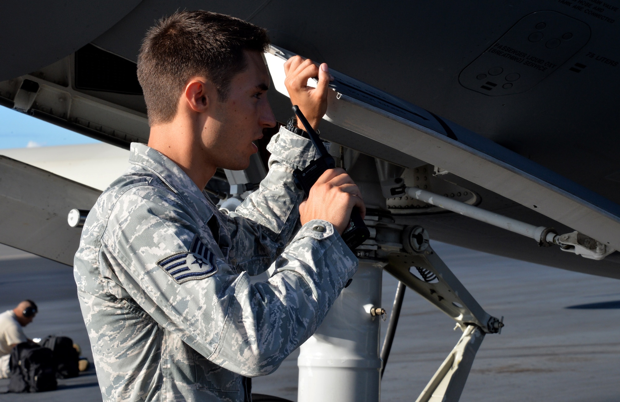 Staff Sgt. Lee Taylor, 15th Aircraft Maintenance Squadron C-17 Globemaster III crew chief, coordinates by radio with the maintenance expediter on the flightline Oct. 9, 2014, at Joint Base Pearl Harbor-Hickam, Hawaii. Taylor oversees the maintenance and inspection work on C-17 aircraft. (U.S Air Force photo by Staff Sgt. Alexander Martinez)