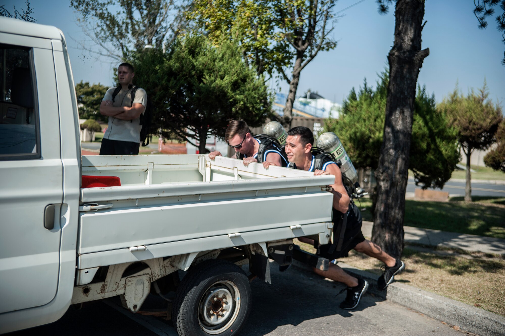 Senior Airman Randall Stoiner, (left) and Tech. Sgt. Julius Ortega, members of 51st Maintenance Operations Flight Mafia team, push a bongo during the Firefighter Challenge for Fire Prevention Week at Osan Air Base, Republic of Korea, Oct. 10, 2014. The 51st MOF Mafia team took first place out of five teams with a time of three minutes and eight second for a course of five obstacles. (U.S. Air Force photo by Senior Airman Matthew Lancaster)