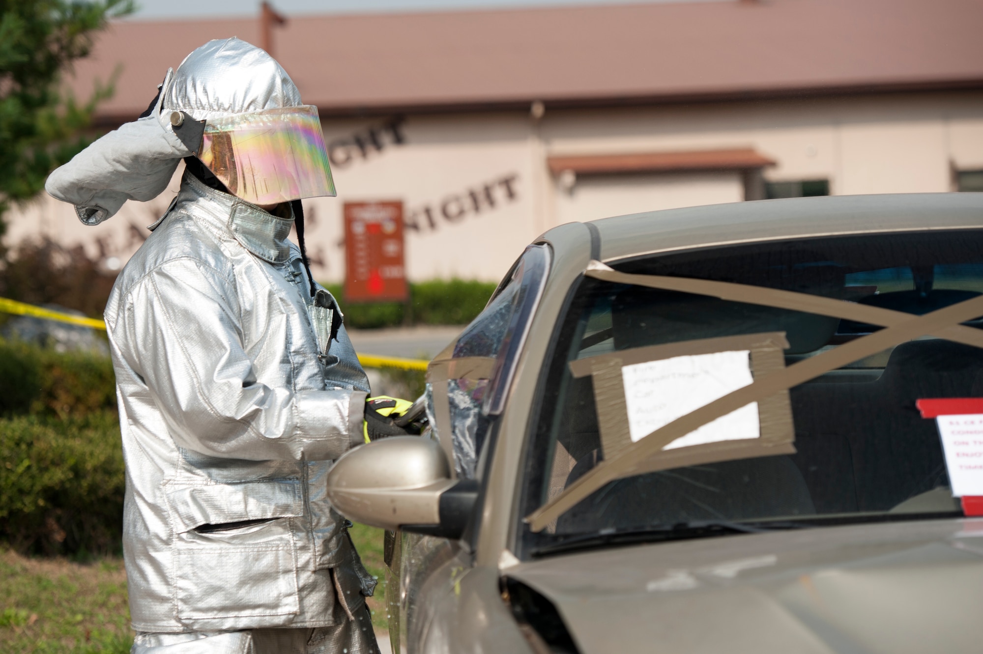 Senior Airman Bryant Hernandez, 51st Civil Engineer Squadron driver operator broke a car window during an Auto Extrication Demonstration for Fire Prevention Week at Osan Air Base, Republic of Korea, Oct. 7, 2014. Fire Prevention Week is the longest running public health and safety observance on record. (U.S. Air Force photo by Senior Airman Matthew Lancaster)