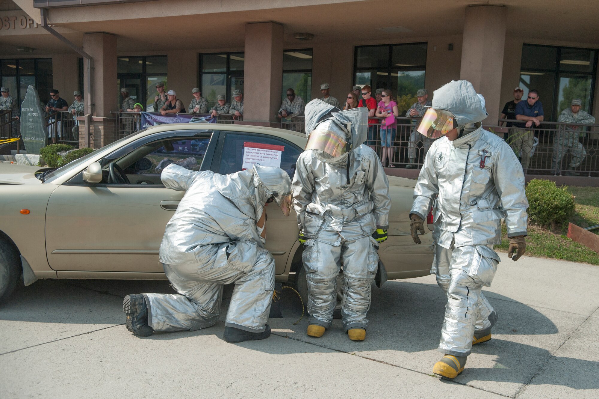 Firefighters from the 51st Civil Engineer Squadron stabilize a car during an Auto Extrication Demonstration for Fire Prevention Week at Osan Air Base, Republic of Korea, Oct. 7, 2014. Fire Prevention Week was established after the 1871 Great Chicago Fire as a way to educate people on fire safety. (U.S. Air Force photo by Senior Airman Matthew Lancaster)
