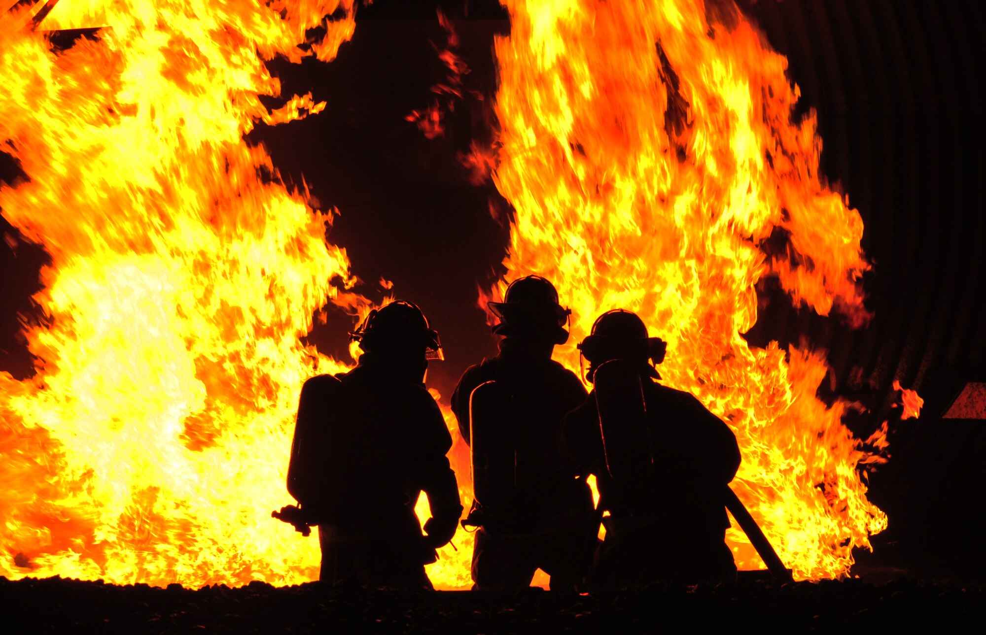 U.S. Air Force firefighters from the 35th Civil Engineer Squadron fight a controlled fire at Misawa Air Base, Japan, Oct. 9, 2014. A live fire demonstration was hosted for friends and families to showcase the base fire department’s firefighting capabilities. (U.S. Air Force photo by Senior Airman Jose L. Hernandez-Domitilo)